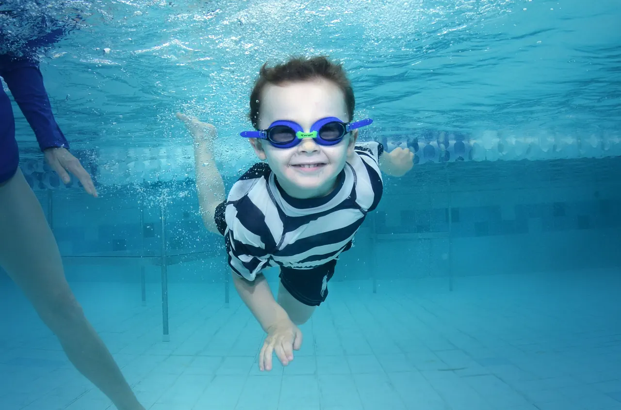 Kind zwemt onder water met een zwembril